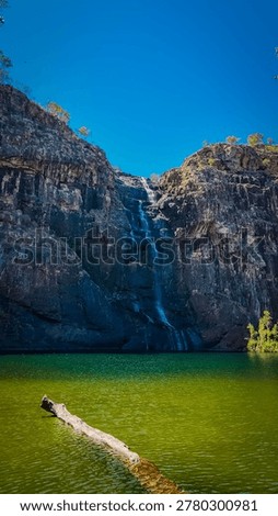 A waterfall cascading down a rock face into a green lake.