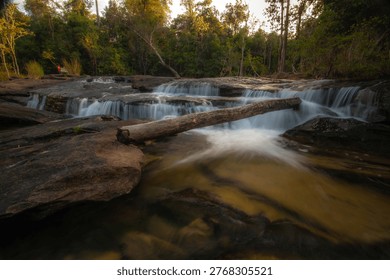 A waterfall cascading down rocks in the forest amidst nature.