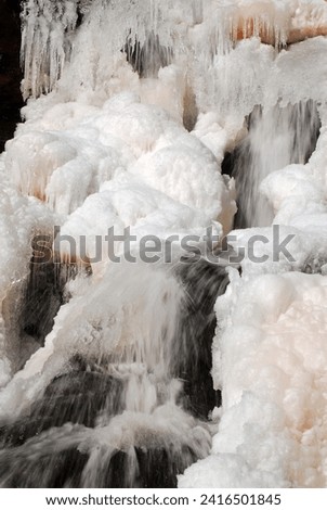A waterfall continues to cascade even with a frozen ice surface