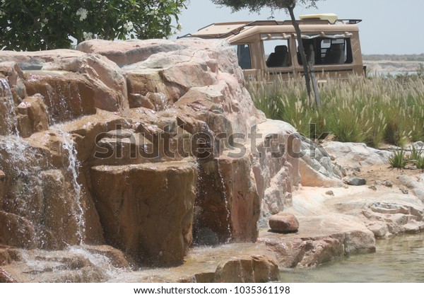 waterfall design\
with a desert car in the\
back