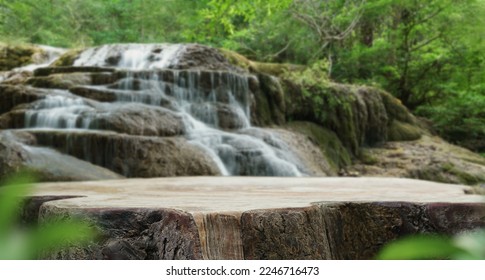 Waterfall with empty table top old wood podium outdoor in tropical forest greenery blurred background.Organic healthy natural product present placement pedestal counter display,nature jungle concept. 
