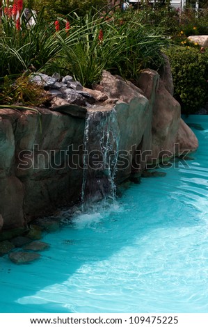waterfall falling in a blue lagoon swimming pool