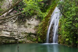 Waterfall Falling Into A  Lake. Bath Of Aphrodite. Cyprus. Tourist Destination, Tourist Attraction, Famous Mythological Site