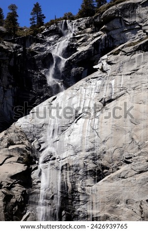 a waterfall falls over the edge of a cliff in the mountains