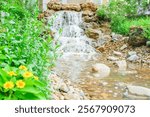 Waterfall is flowing in jungle,Waterfall flowing through rocks in green forest,Stream of water in the forest, Cascading stream in lush forest. Nature background. Rock or stone at waterfall.