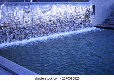 A waterfall flowing at park. A waterfall of a fountain in a garden. Wall of water. A beautiful view of the falling water cascade. Artificial waterfall, city fountain, close-up pouring water - Shutterstock ID 2170598825