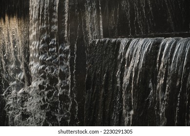 A waterfall flowing at park Wall of water A beautiful view of the falling water cascade city fountain close-up pouring