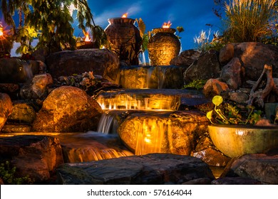 Waterfall fountain landscape at night with gold color lights and tiki