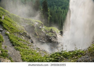  waterfall from a high cliff. water flow down.Streams of water crash on rocks and boulders. stormy stream of water with drops and splashes.Downward movement of water.