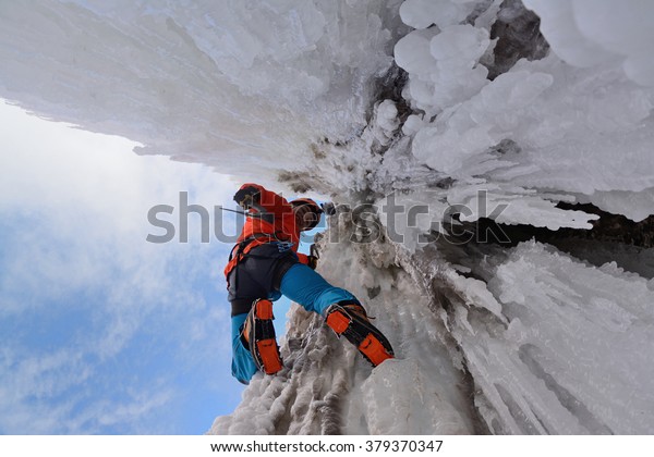 Waterfall ice climbing in a\
sunny day