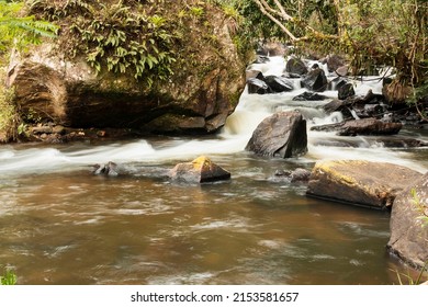 Waterfall With A Large Volume Of Water That Flows Through Several Rocks.