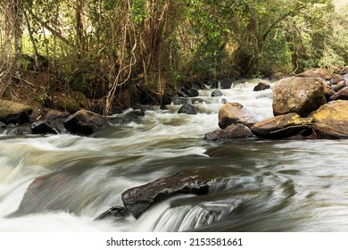 Waterfall With A Large Volume Of Water That Flows Through Several Rocks.