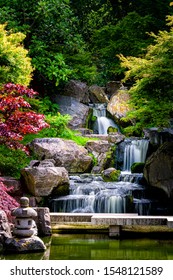 Waterfall long exposure vertical view with maple trees in Kyoto Japanese green Garden in Holland Park green summer zen lake pond water in London, UK