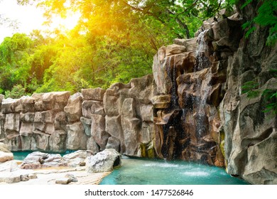 Waterfall model simulation  landscape from man made or artificial with stone and tree forest,sunlight  at natural environment in the zoo park for exhibiting or animal show.