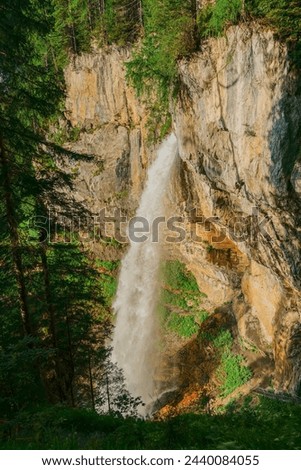 Waterfall in the mountains. Rushing water falls on large stones.Water boils and pours over boulders and stones.stream of water with drops and splashes