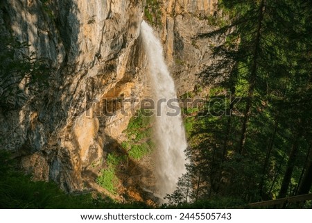 Waterfall in the mountains. Rushing water falls on large stones.Water boils and pours over large boulders and stones.stream of water with drops and splashes