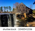 The waterfall and the old gristmill with its flume and waterwheel at Historic Yates Mill County Park at Raleigh North Carolina, Triangle area, Wake County.