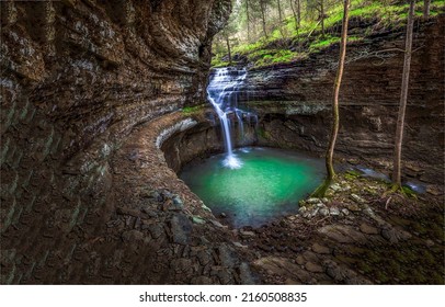 Waterfall pool in forest cave. Beautiful waterfall in forest cave. Forest cave waterfall pool. Waterfall in cave landscape