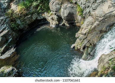 Waterfall Pouring Into A Swimming Hole.