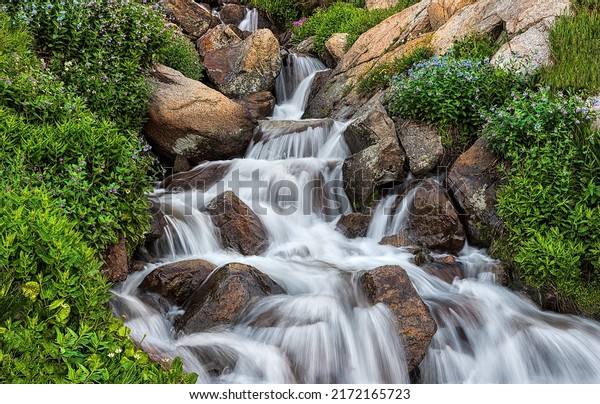 Waterfall from the stream flows over the stones.\
Waterfall stream on rocks. Cold creek flow on waterfall rocks.\
Waterfall rocks