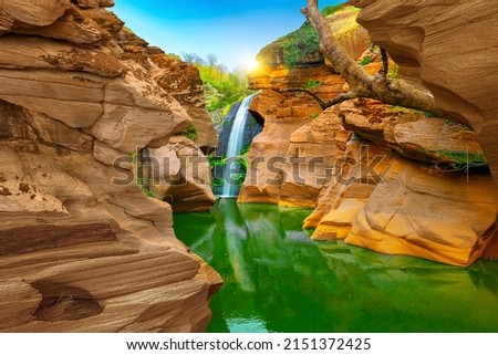 waterfall view in the canyon. wonderful rock forms created by erosion. View of the river in the canyon. waterfall landscape in nature. beautiful landscape in the red valley.  landscape photography.