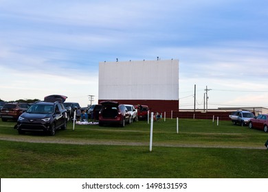 Waterford, PA / United States - September 2019 : Sunset Drive In Movie Theater With Cars Outdoor Movie Screen Blue Sky Green Grass