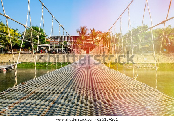 Waterfront is bridge made with sling at in\
Phetchaburi Province in Thailand on the banks of the river.The\
result of the cooperation of the two parishes. It is preserve and\
restore nature along \
River.