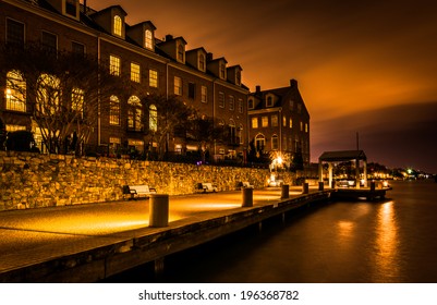 Waterfront condominiums and promenade along the Potomac River at night in Alexandria, Virginia.