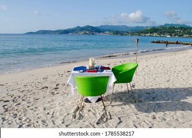 Waterfront dining at table set for two on Grand Anse Beach, south coast, Grenada, Caribbean.