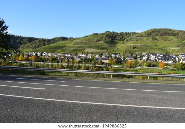 waterfront road through vineyard landscape near\
Müden in Mosel\
valley