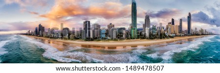Waterfront of Surfers Paradise Gold Coast city scape urban towers over wide sandy long beach on Australian Pacific coast in Queensland - aerial panoramic view from sea.