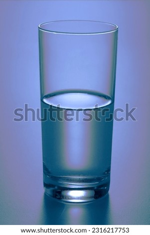 A waterglass half full of water.
