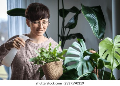 Watering houseplants woman caring home jungle - Powered by Shutterstock