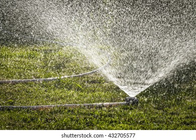 Watering The Lawn Of A Private House With The Help Of Irrigation Sprinkler