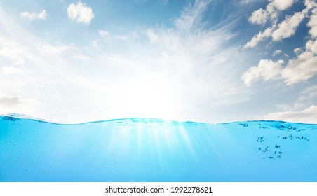 Waterline with sea underwater and blue sunny sky with clouds