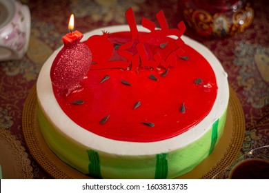 A Watermelon Cake In Red With A Pomegranate Candle In Celebration Of Yalda Night ( The Longest Year Of The Night In Persian Culture) The Sign Says : 