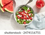 Watermelon light summer salad with lettuce, young goat cheese, watermelon and spices, served with watermelon smoothie. Light summer recipes, dietary fruit salads. Sunlight, white table