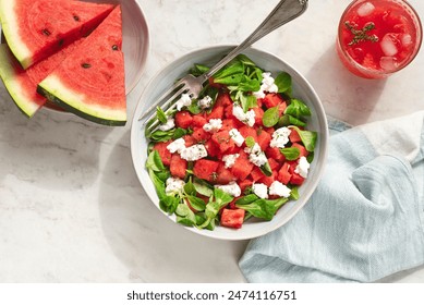 Watermelon light summer salad with lettuce, young goat cheese, watermelon and spices, served with watermelon smoothie. Light summer recipes, dietary fruit salads. Sunlight, white table - Powered by Shutterstock