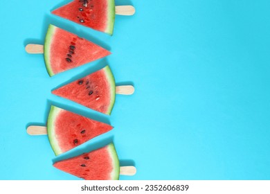 Watermelon on a wooden ice cream stick on a blue background. Creative food concept. - Powered by Shutterstock