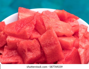 Watermelon pieces in bowl near the swimming pool.