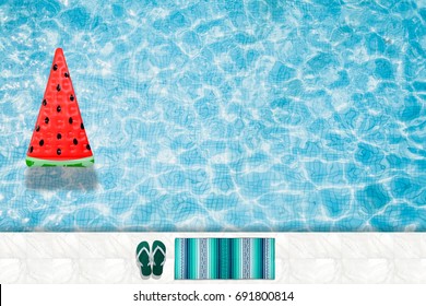 Watermelon pool float, ring floating in a refreshing blue swimming pool with palm tree leaf shadows in water