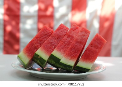 Watermelon Slices In Front Of United States Flag, Outside At A Summer Barbecue, As For Memorial Day Or The Fourth Of July / Independence Day.