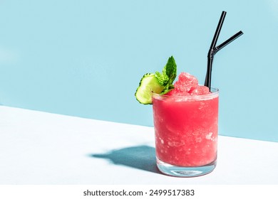 Watermelon slushie or strawberry granita cocktail with mint in glass on tendy blue background, copy space.  Refreshing cold summer shaved ice sorbet drink, minimal shot with hard light. - Powered by Shutterstock