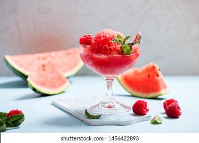 Watermelon slushy with raspberry in weeping glass, summer refreshing drink, frozen, watermelon smoothie or granita, vegan dessert
