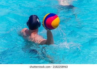Waterpolo game swimmer player unrecognizable  behind rear photo with ball in hand play action closeup .