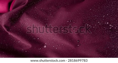 Waterproof fabric texture with rain drops closeup. Water resistant deep pink cloth, macro droplets on textile, wet material surface, water proof jacket macro pattern with selective focus