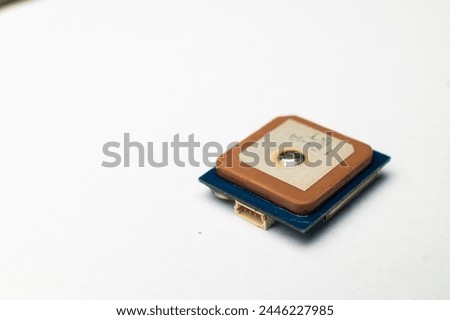 Waterproof GPS module with ceramic antenna on a white background in soft focus. Electronic components for hobby and assembly of FPV multicopters