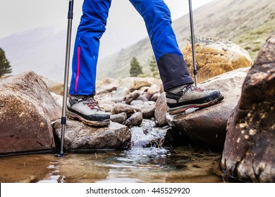 Waterproof trekking boots wade a rocky mountain stream. The concept of high quality hiking equipment - Powered by Shutterstock