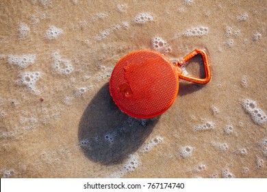 Waterproof Wireless Speaker On The Beach Wet By The Waves