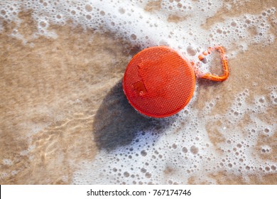 Waterproof Wireless Speaker On The Beach Wet By The Waves